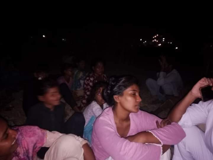 Children and adults huddled together on a threshing floor, a temporary sanctuary from the violence.