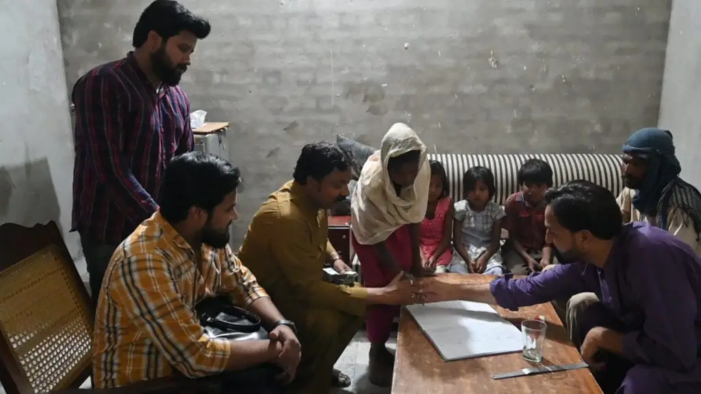 Mehboob Masih and his family signing paperwork to finalize their release from brick kiln slavery