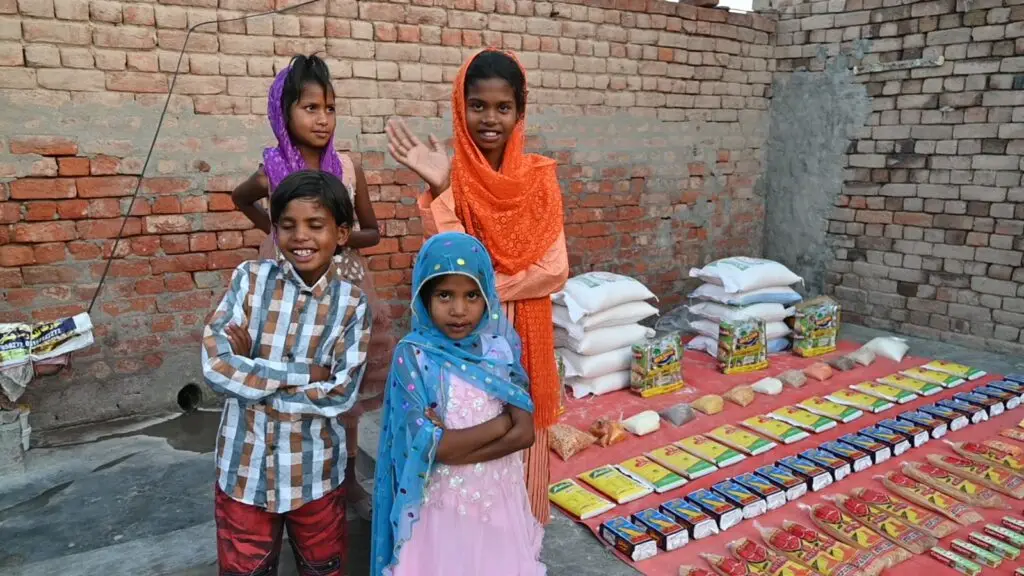 Mehboob Masih and his children standing with their new supplies after being rescued from brick kiln slavery