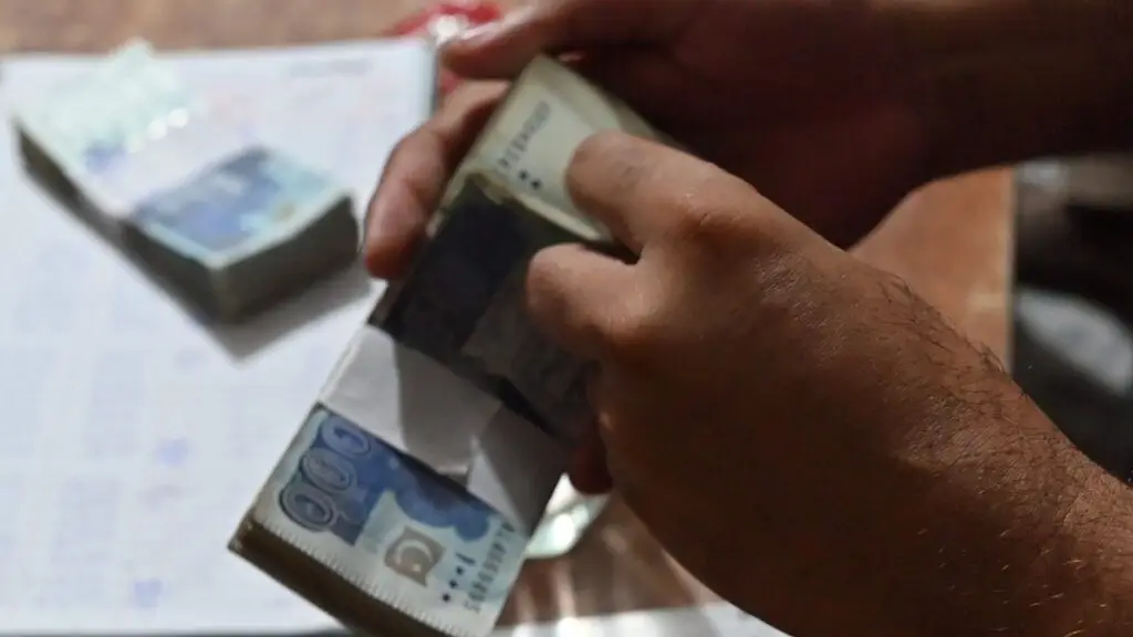 Close-up of hands counting money to repay the debt of Mehboob Masih's family