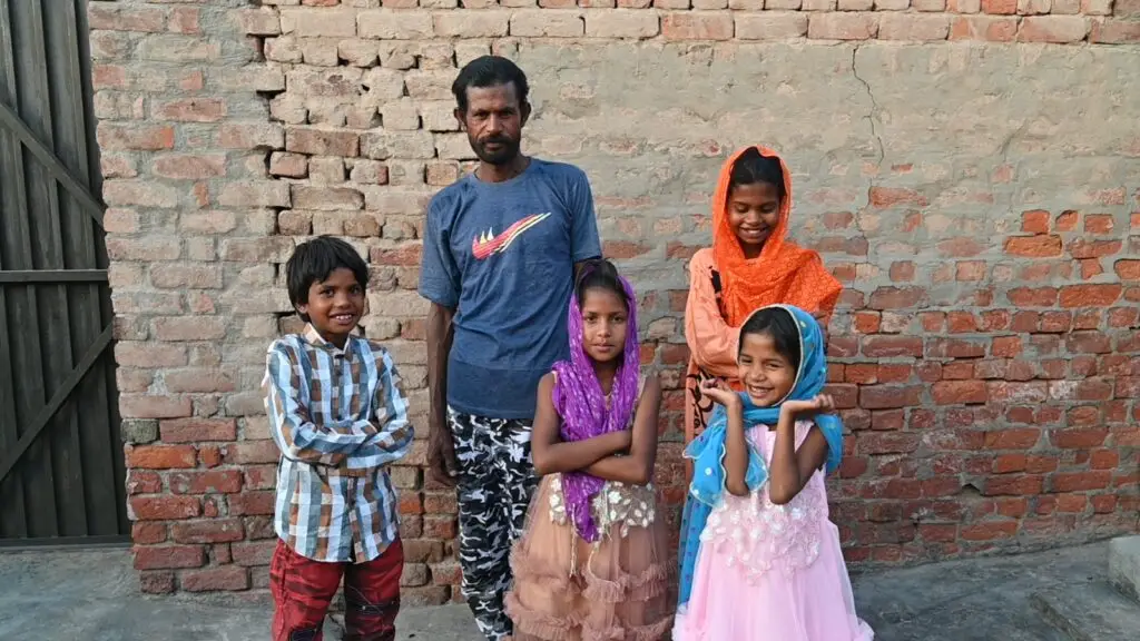 Mehboob Masih and his children posing in their new clothes after being rescued from brick kiln slavery